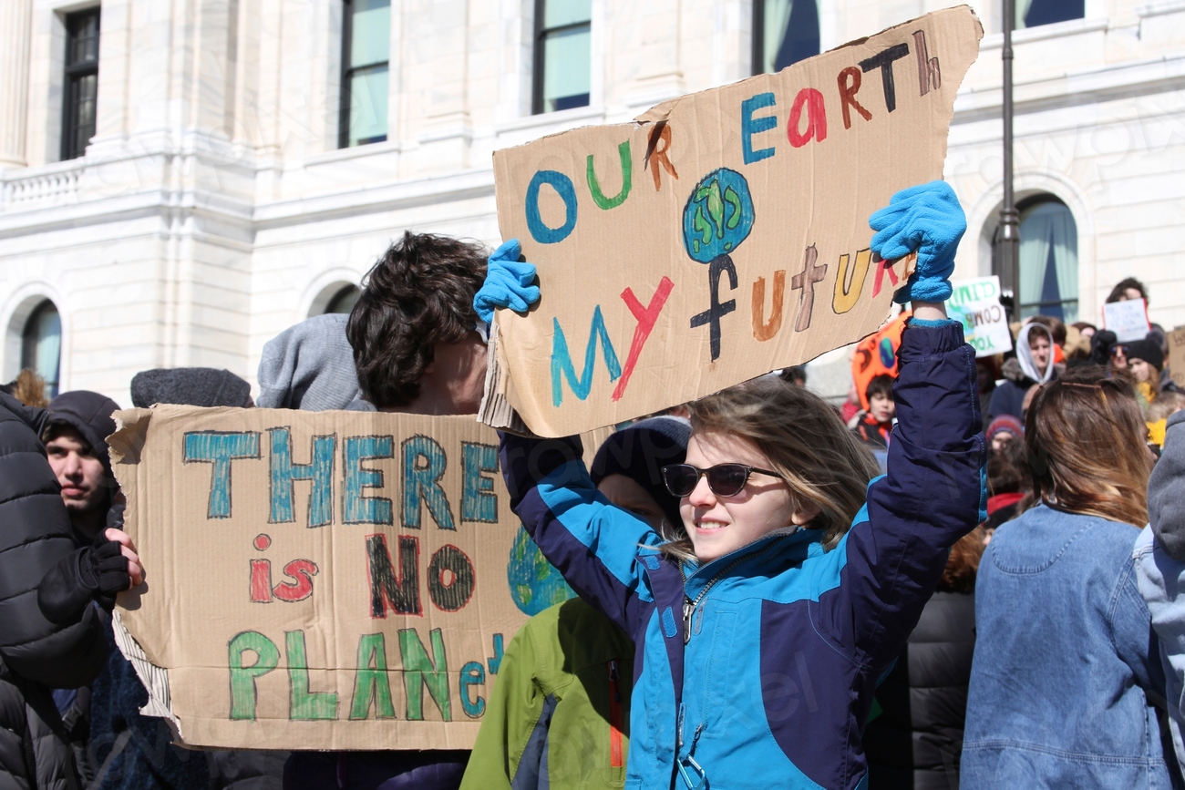 Young people hold up climate banners at a Youth Climate Strike.