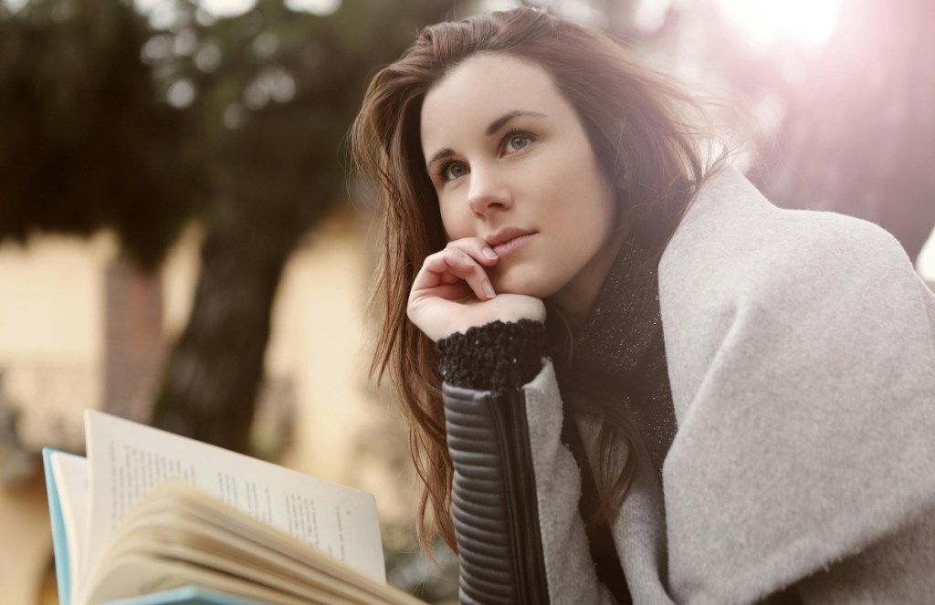 A woman with a notebook, thinking.
